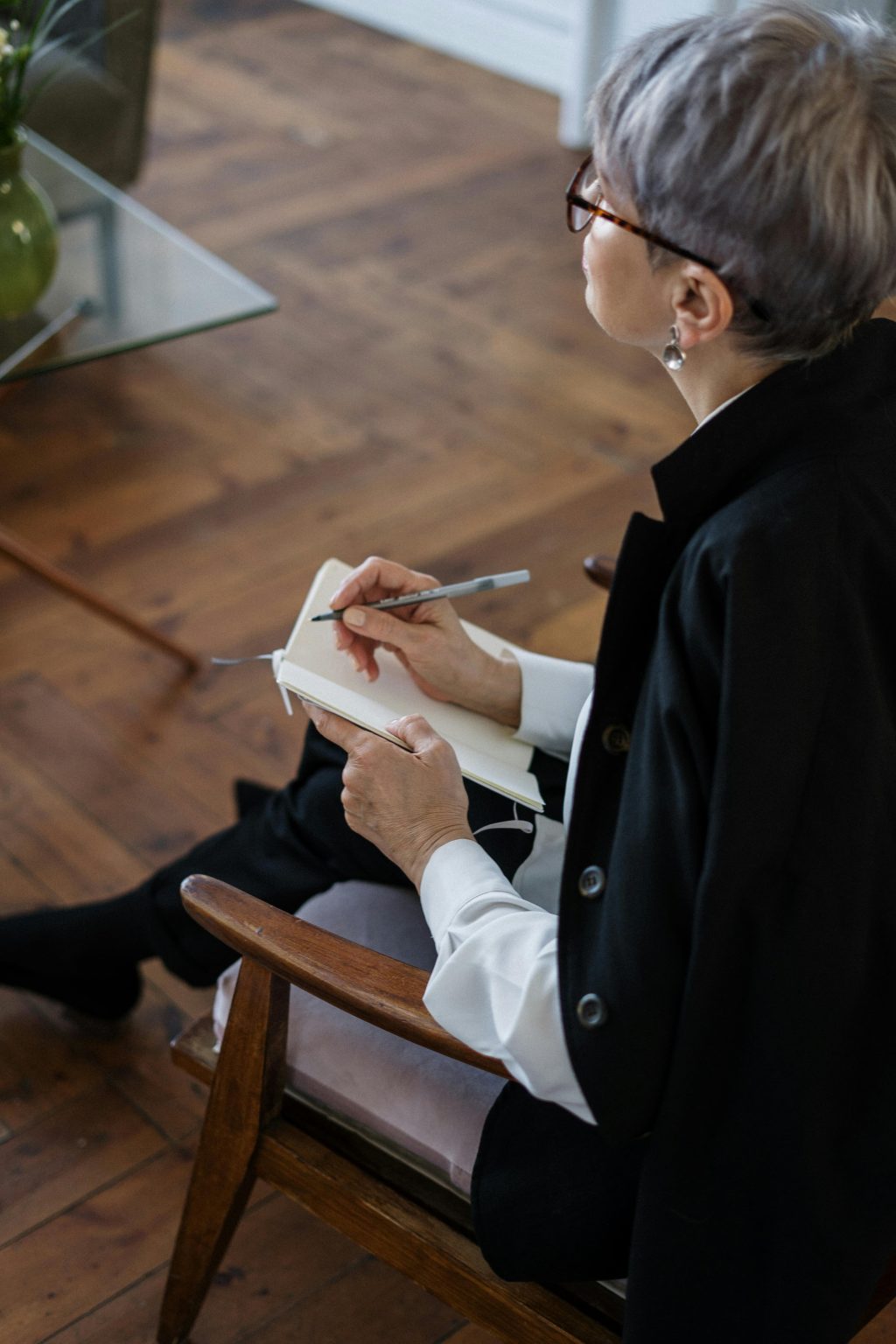 Image of an older woman with short graying hair with a notebook.