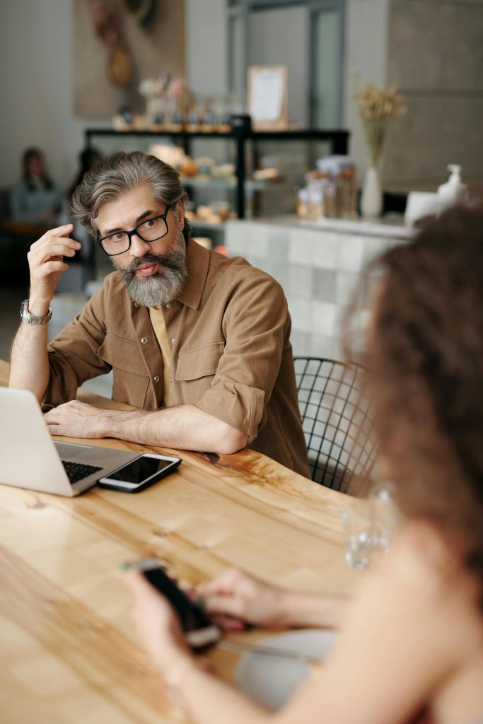 Image of two professionals sitting at a wooden table.