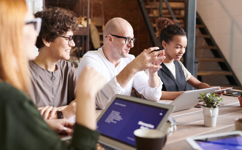 Image of three professionals working on a project together at a table.