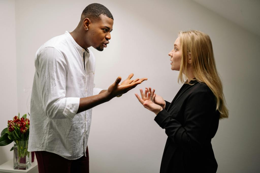 Image of a Black man and a white woman engaged in an argument